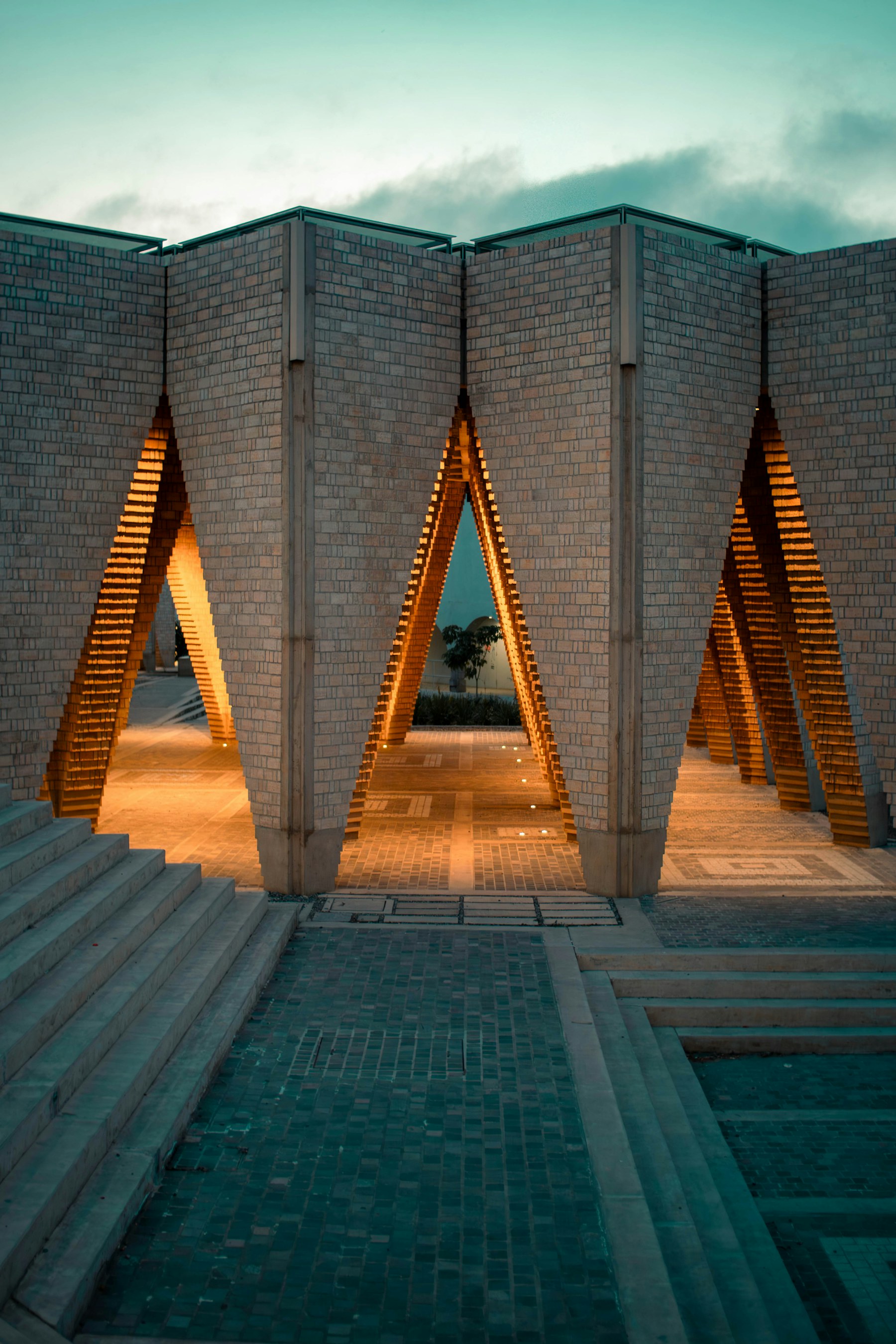 Warm architectural lighting in a brick pavilion at dusk