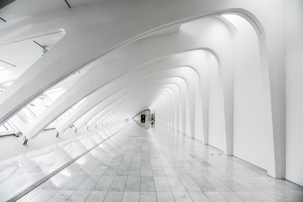 Curved interior corridor lit by concealed warm cove lighting